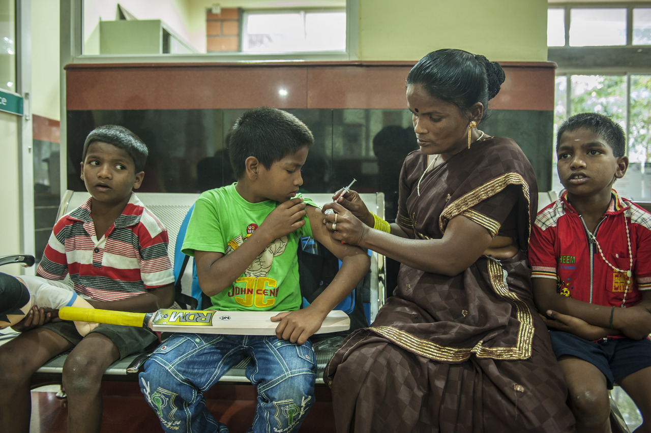 Trẻ em và một phụ nữ ở Bangalore, Ấn Độ, ngồi xuống.